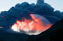 Ash plume from the volcano under the Eyjafjallajokull ice cap, coloured red by the rising Sun, Iceland, 7 May 2010