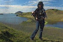 Photographer Orsolya Haarberg surrounded by swarming Midges (Chironomus islandicus) Myvatn, Iceland, June 2008, model released