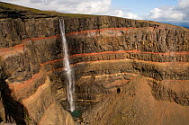 Hengifoss waterfall falling over layers of grey basalt and reddish sandy clay, Iceland, August 2008
