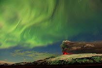 Subglacial volcanic eruption under the Eyjafjallajokull ice cap with northern lights above the ash plume at night, Iceland, April 2010