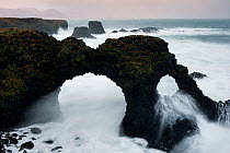 Coastal rocks including an arch in winter storm, Arnarstapi, Snaefellsnes peninsula, Iceland, January 2011