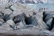 People walking on Svinafellsjokull glacier in the Vatnajokull ice cap, Skaftafell National Park, Iceland, March 2011