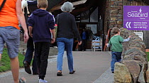 Visitors walking towards the entrance to the Scottish Seabird visitor Centre, North Berwick, East Lothian, Scotland, August 2011