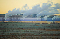 View over frost covered Elmley Marshes towards  cooling towers of nearby industrial site, Elmley Marshes RSPB, Kent, UK, February 2012