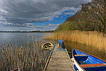 Dinghy moored to jetty on Filby Broad in Trinity Broads, Norfolk Broads, Norfolk, UK, April
