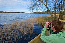 Boy birdwatching at Ormesby Little Broad, Trinity Broads, Norfolk Broads, Norfolk, UK, April 2012, model released