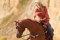 Woman riding Arabian stallion, Ojai, California, USA, model released