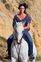 Woman riding Arabian stallion, Ojai, California, USA, model released