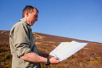 Planting contractor examines map before native tree planting at Abernethy Forest, Cairngorms National Park, Scotland, March 2012.