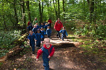 Children from Rowley View Nursery School walking in the Moorcroft Environmental Centre Forest School, Moorcroft Wood, Moxley, Walsall, West Midlands, July 2011. Model released.