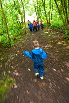 Children from Rowley View Nursery School walking in woodland at the Moorcroft Environmental Centre Forest School, Moorcroft Wood, Moxley, Walsall, West Midlands, July 2011. Model released.