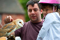 Man and child looking at Barn Owl at the Black Country Living Wildlife Roadshow, Sandwell Park Farm, West Bromwich, West Midlands, August 2011.  Did you know? Although owls have excellent night vision...