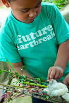 Child with craftwork at the Black Country Living Wildlife Roadshow, Sandwell Park Farm, West Bromwich, West Midlands, August 2011. Model released.