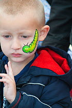 Child with caterpillar face painting at the Black Country Living Wildlife Roadshow, Sandwell Park Farm, West Bromwich, West Midlands, August 2011. Model released.
