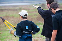 Young volunteers clearing scrub, RSPB Vange Marshes reserve, Basildon, Essex, England, UK, November 2011. Model released.