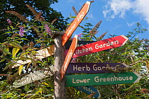 Signpost in Brockwell Park Community Garden, with flowering Buddelia in the background, London. England, UK, August