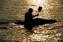 Kayaker silhouetted at sunset near Inner Farne, Farne Islands, Northumberland, August, 2011.