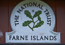 Close up of National Trust sign for the Farne Islands, on a wooden door, Inner Farne, Northumberland, June 2010.