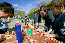 Volunteer children making useful items as part of skill learning course at community city farm, Swansea, Wales, April 2009.