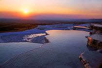 Hot springs and travertines (terraces of carbonate minerals left by the flowing water) at sunset, Pamukkale, near Denizli, Turkey, June 2006