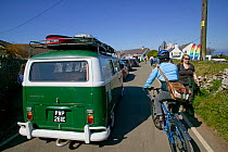 Holiday traffic queing for coastal car park, including camper van and cyclist, Rhosilli, Gower, South Wales, April 2009