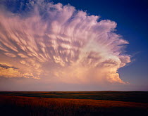 Cheyenne River Sioux Tribal Park with severe storm clouds at sunset amid vast grassland, South Dakota, USA