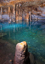 Stalagmites and stalactites with turquoise waters of Cenote Papakal, near Merida, Yucatan, Mexico