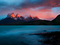 The blue green waters of Lago Pehoe, with the sunset light on Los Cuernos del Paine, in Torres del Paine National Park, Chile