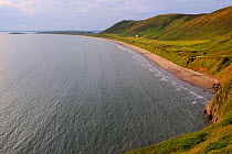 Overview of Rhossili Bay at high tide with waves lapping sandy beach below Rhossili Down, The Gower peninsula, Wales, UK, July. Sequence 2 of 2 matching view with different tides
