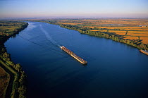 Aerial view of commercial barge transporting goods down the Rhone to the Mediterranean Sea, Salin de Giraud, Camargue, France
