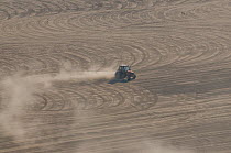 Aerial view of tractor levelling the rice field before sowing a new crop, Camargue, Southern France, September 2009