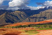 Farmland and settlement above the Sacred Valley with the Urubamba Cordillera of the Andes behind, near Cusco, Peru. November 2005
