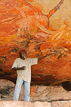 Aboriginal cave art being explained by guide Arnhemland, North West Territories, Australia, May 2009