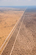 Aerial view of the results of a bushfire in the Kalahari desert, showing the road acting as a fire break, fires are normally lit by lightning in the beginning of the rainy season, Botswana, November.