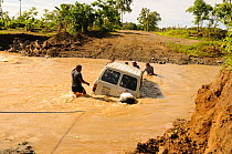 Group of men attempting to rescue a vehicle stuck in flood water, River Camerones, Manabi province Ecuador. February 2012. No release available.