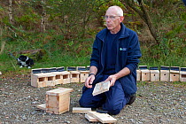 Man demonstrating birdbox building as part of Flora of the Fells day. Helvellyn, Lake District National Park, Cumbria, September.