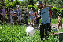 Entomologist Pete 'The Bug Man' Dawson sweeping for insects during Arnos Vale Cemetery Bioblitz as members of the public watch, Bristol, UK, May 2012