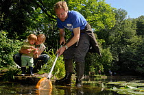 Family pond dipping with other pond-dippers in the background during Abbots Pool and woodland reserve Bioblitz, Bristol, UK, June 2012. Model released. Nominated in Melvita Nature Images Awards compet...