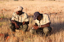 Save the Rhino Trust trackers, Erwin Karatjiva and Dansiekie Ganaseb, recording black rhino sighting, Palmwag concession, Kunene region, Namibia, May 2009. Editorial use only
