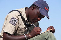 Save the Rhino Trust tracker, Dansiekie Ganaseb, recording black rhino sighting, Palmwag concession, Kunene region, Namibia, May 2009. Editorial use only