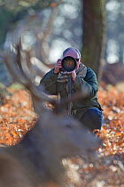 Wildlife photographer Tony Heald photographing Red deer in Richmond Park, London, UK January 2012. Model released.