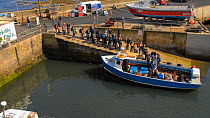 Timelapse of tourists boarding a boat to take them to the Farne Islands, Seahouses Harbour, Northumberland, England, UK, July 2011