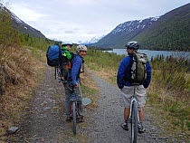 Two men and a toddler take a break from mountain biking on the Russian River Falls trail. Kenai National Wildlife Refuge, Chugach National Forest, Alaska, May 2012.