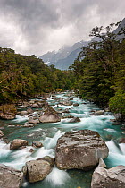 Looking up the Tutoko River from historic suspension bridge. Stormy clouds covering mountains peaks, Tutoko River, Fiordland National Park, South Island, New Zealand, February, 2005.