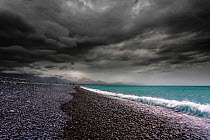 Moody sky over stoney beach, with mountains just visible in the background, Kaikoura, Canterbury, South Island, New Zealand. September, 2006.
