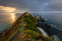 Nugget Point (Ka Tokata) Lighthouse at sunrise, rain clouds sweeping in from the horizon, Catlins, Clutha District, Otago, South Island, New Zealand. October, 2006.