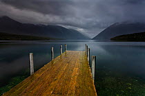 Lake Rotoiti and jetty in moody evening light, rain clouds sweeping over the surrounding moutains. Looking south, towards the Travers River Valley, Nelson Lakes National Park, Saint Arnaud, Tasman Reg...