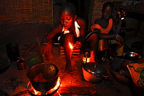 Cooking in a cabin without electricity in a small village,   Bassari country, east  Senegal. The Bassari, Fula and Bedik people keep alive their ancient traditions and customs, and UNESCO declared a W...