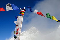 Buddhist prayer flags in front of Mount Everest shrouded in mist, from Kala Pattar (5545 m). Sagarmatha National Park (World Heritage UNESCO). Khumbu / Everest Region, Nepal, Himalaya, October 2011.