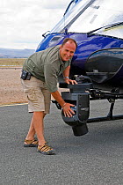 Cameraman Martyn Colbeck with mounted Cineflex camera on helicopter. Amboseli, Kenya. December 2007. Taken on location for BBC tv series 'Life'